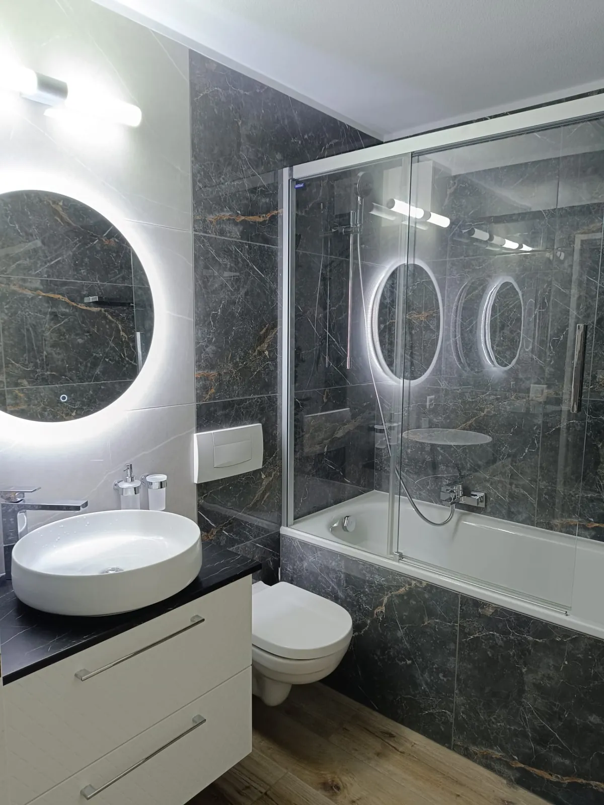 Salle de bain complète avec carrelage effet marbre et baignoire-douche