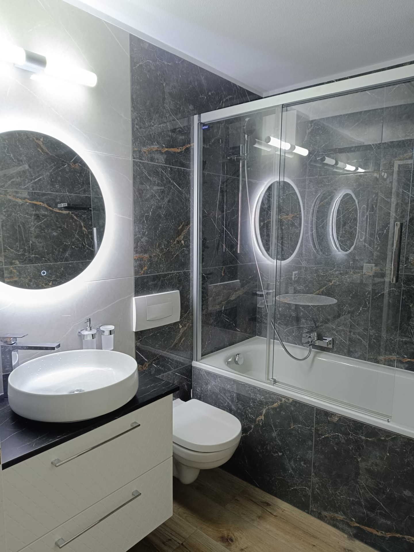 Salle de bain complète avec carrelage effet marbre et baignoire-douche